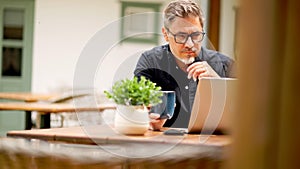 Man working with laptop at home outdoor on terrace