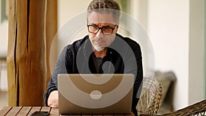 Man working with laptop at home outdoor on terrace