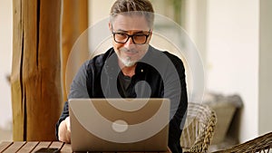 Man working with laptop at home outdoor on terrace