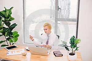 Man working on laptop from office. Counting financial data