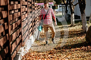 Man working with leaf blower in back yard