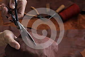 Man working with leather using scissors.