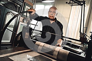 Man working on lithography machine looking camera serious balck and white photo