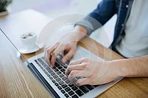 Man working on a macbook or laptop in cafe photo