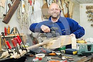 Man working on a machine at guitar workshop