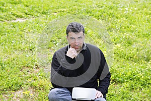Man working on meadow grass notebook computer