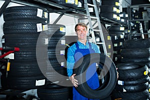 man working with new tyre for car