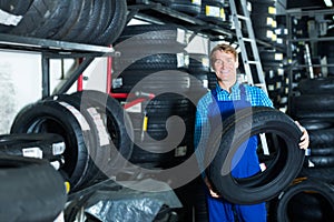 Man working with new tyre for car