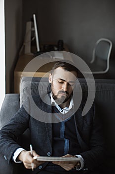 Man Working In Office Doing Notes