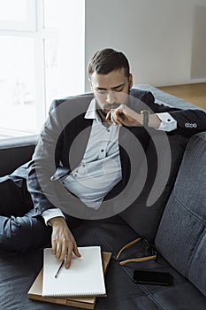 Man Working In Office Doing Notes