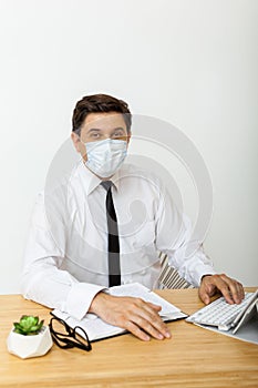 Man working in the office in a medical mask