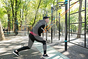 Man working out with elastic band on sports ground