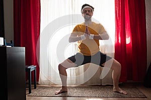 Man working out, training, Goddess Pose, temple or sumo pose