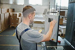 Man working in printing house with paper and paints