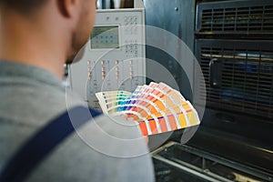 Man working in printing house with paper and paints