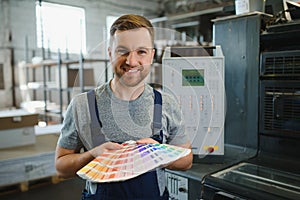 Man working in printing house with paper and paints