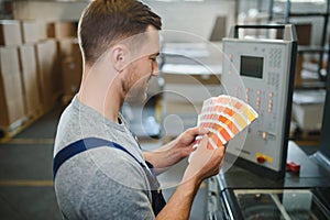 Man working in printing house with paper and paints