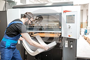 Man working with printing machine at the manufacturing