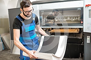 Man working with printing machine at the manufacturing