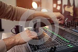 Man working with professional mixing console in modern radio studio, closeup