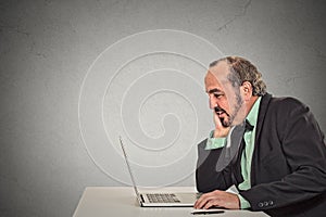 Man working reading something on his laptop computer