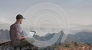 Man working remotely outdoors with laptop
