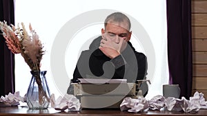 Man Working on a Retro Typewriter at Desk