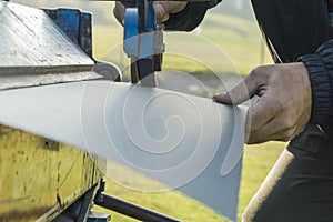 Man working on roof metal sheet in site construction