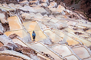 Man working the salt evaporation ponds in Maras, Peru