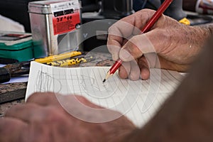 Man writing on a notebook with some tools around photo