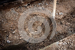 Man working with a shovel in clay.