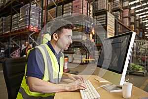Man working in on-site office at a distribution warehouse