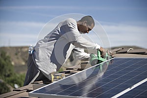 Man Working On Solar Panelling On Rooftop photo