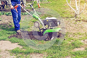 Man working in the spring garden with tiller machine photo