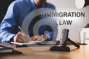 Man working at table, focus on gavel. Immigration law