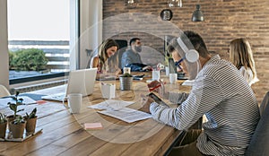 Man working with tablet and headphones in an office