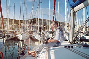 Man is working during the vacation on a sailboat