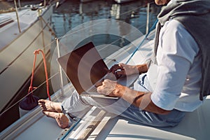 Man is working during the vacation on a sailboat