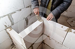 A man is working on a wall with a trowel