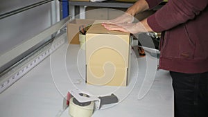 Man Working in a Warehouse assembling a Box