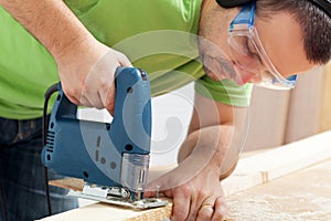 Man working wood with electric saw
