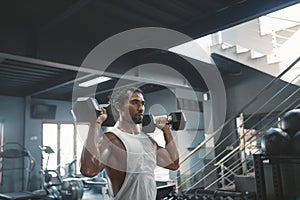 Man Workout With Dumbbells At Gym. Asian Sportsman On Intense Training At Fitness Center.