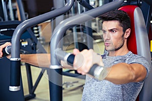 Man workout on fitness machine in gym