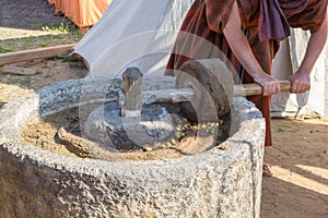 Man works at ancient Roman press for olive oil