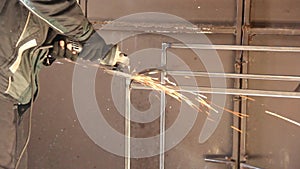 A man works with an angle grinder. Sparks from the grinder. Metal grinding process