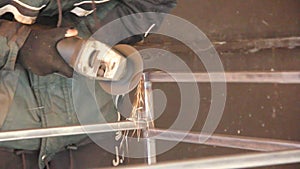 A man works with an angle grinder. Sparks from the grinder. Metal grinding process