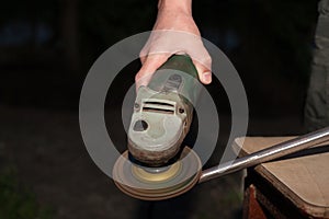 A man works with a blacksmith`s disc grinder.