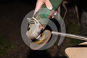 A man works with a blacksmith`s disc grinder.