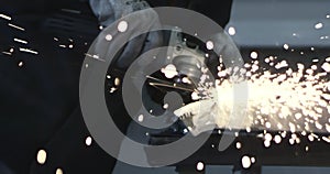 Man works circular saw. Sparks fly from hot metal. Man hard worked over the steel. Close-up slow motion shot in garage