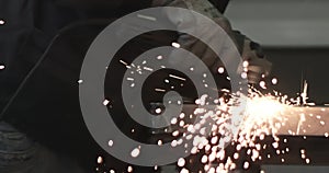 Man works circular saw. Sparks fly from hot metal. Man hard worked over the steel. Close-up slow motion shot in garage